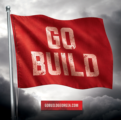 A red flag on a flagpole with the words Go Build in white and the text gobuildgeorgia.com underneath it